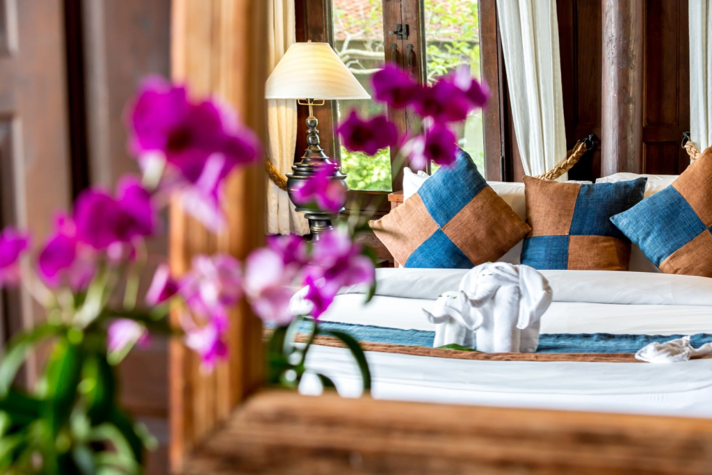 Bedroom with orchids beside the bed at Villa Arun