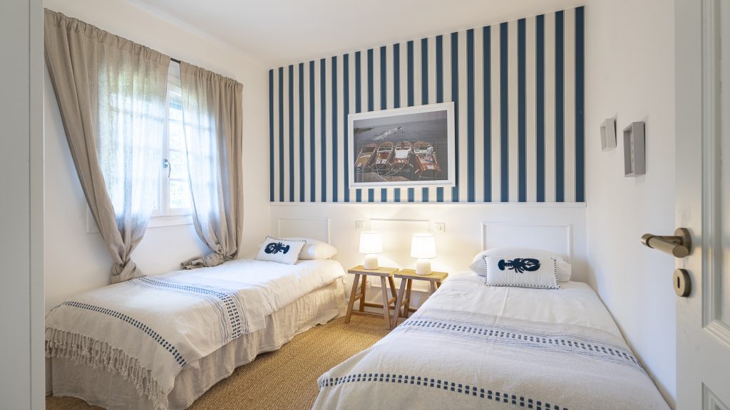 Bedroom with two beds and a striped feature wall at Tanneron Villa