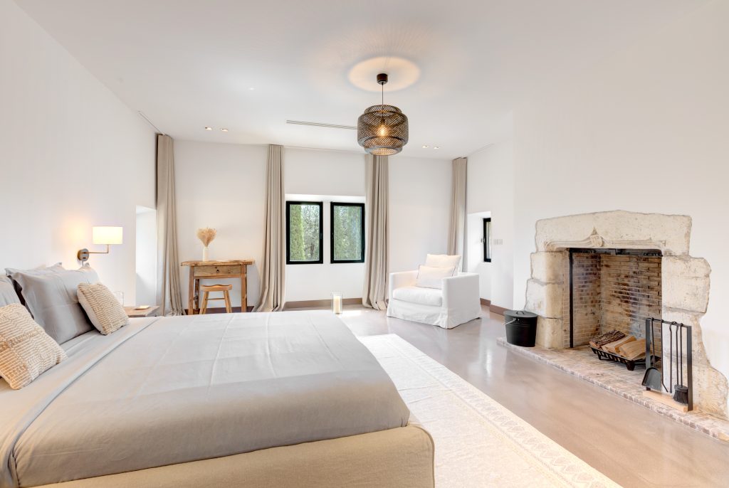 Le Castel bedroom with fireplace and garden view