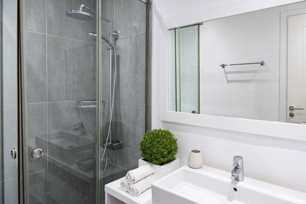Bathroom with a stone shower and mirror at Kastalia Estate