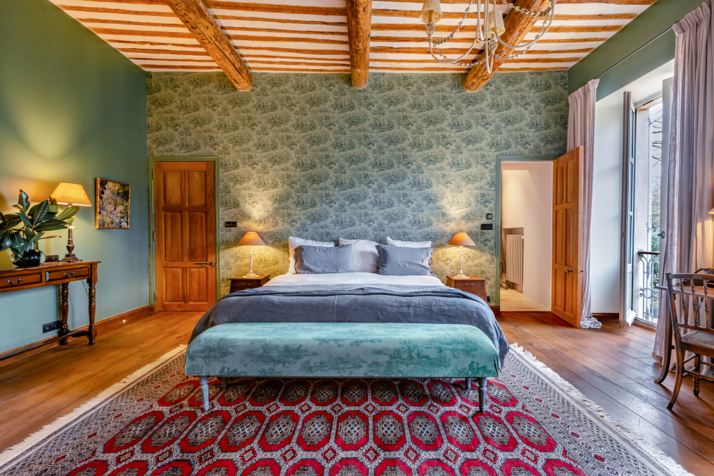 Bedroom with a king bed and patterned walls at Domaine du Levant