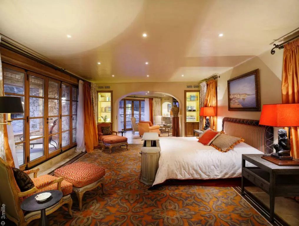 Bedroom with a large bed and warm wood finishes at Fréjus Luxury Estate