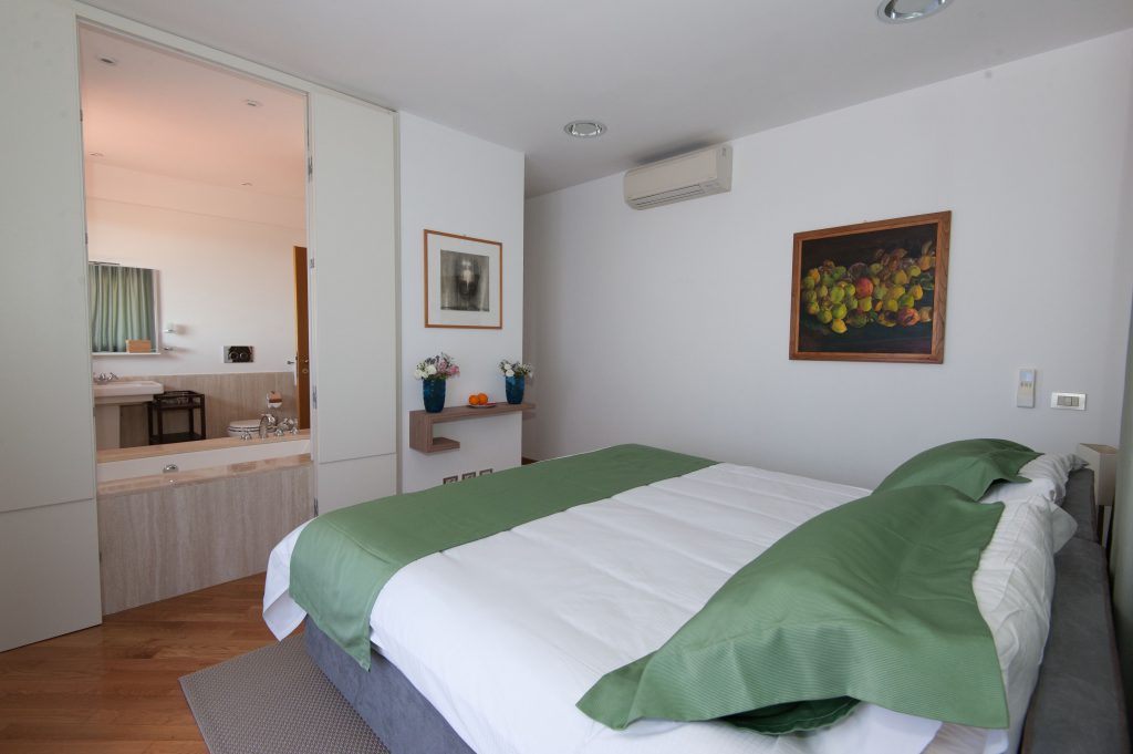 Bedroom with green bedding at La Sabina Tennis Estate