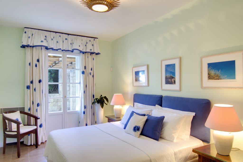 Bedroom with a double bed and blue sofa at Villa Eos