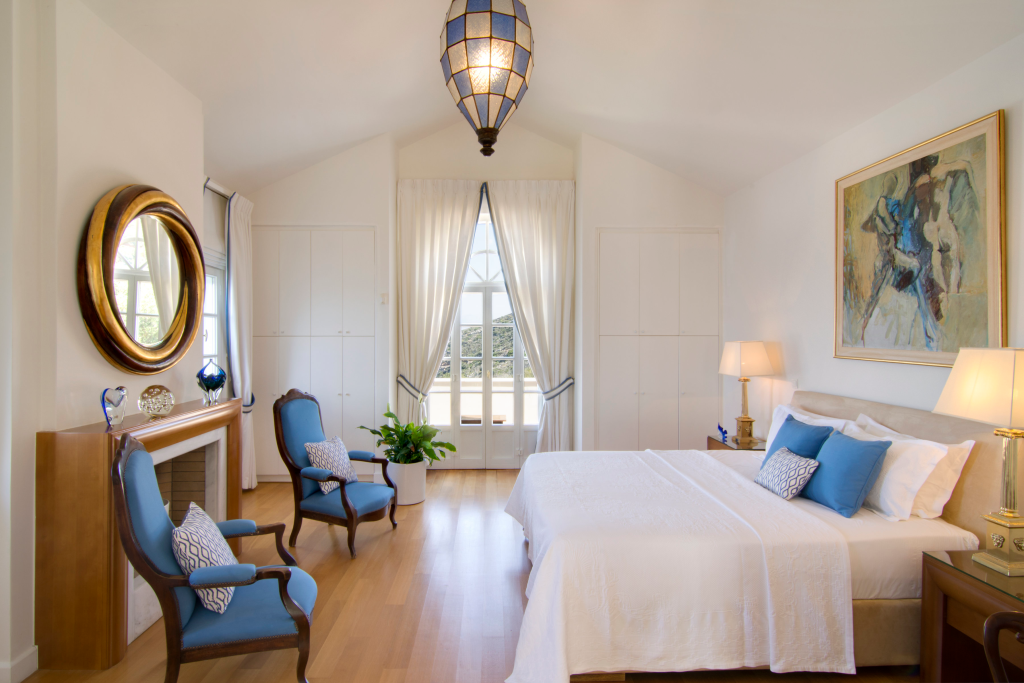 Bedroom with a double bed and sea-blue accents at Villa Eos