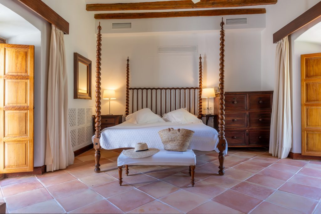 Four-poster bedroom with a sitting area at Villa Solana