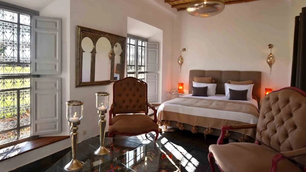 Bedroom with a king bed and carved wooden shutters at Domaine Orielle