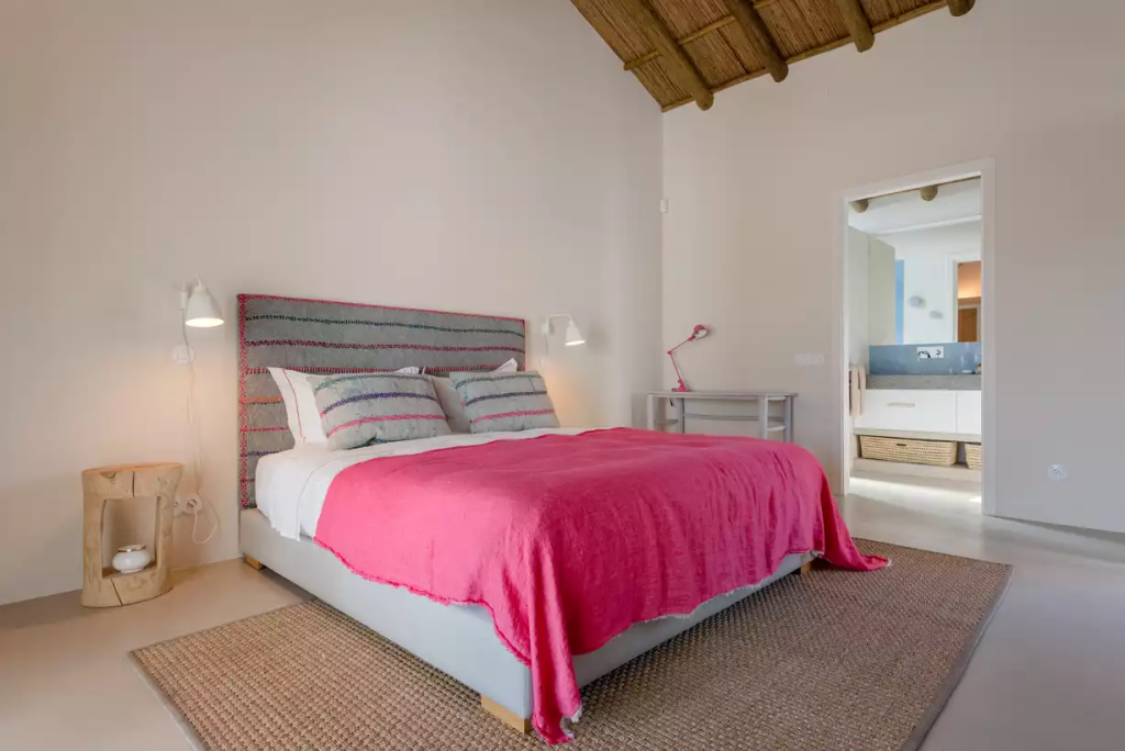 Bedroom with a pink headboard at The Alba Estate