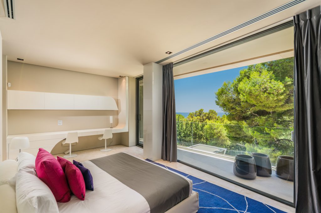 Suite with a bed beside floor-to-ceiling glazing at Villa Era