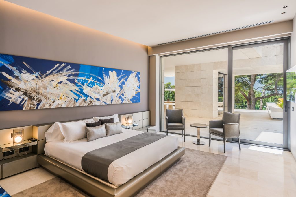 Suite with a king bed and artwork above the headboard at Villa Era