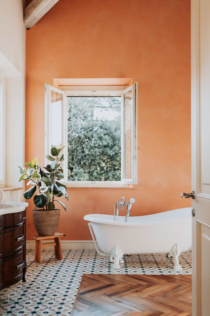 Bathroom with a freestanding bath by a window at Tenuta Cassiana