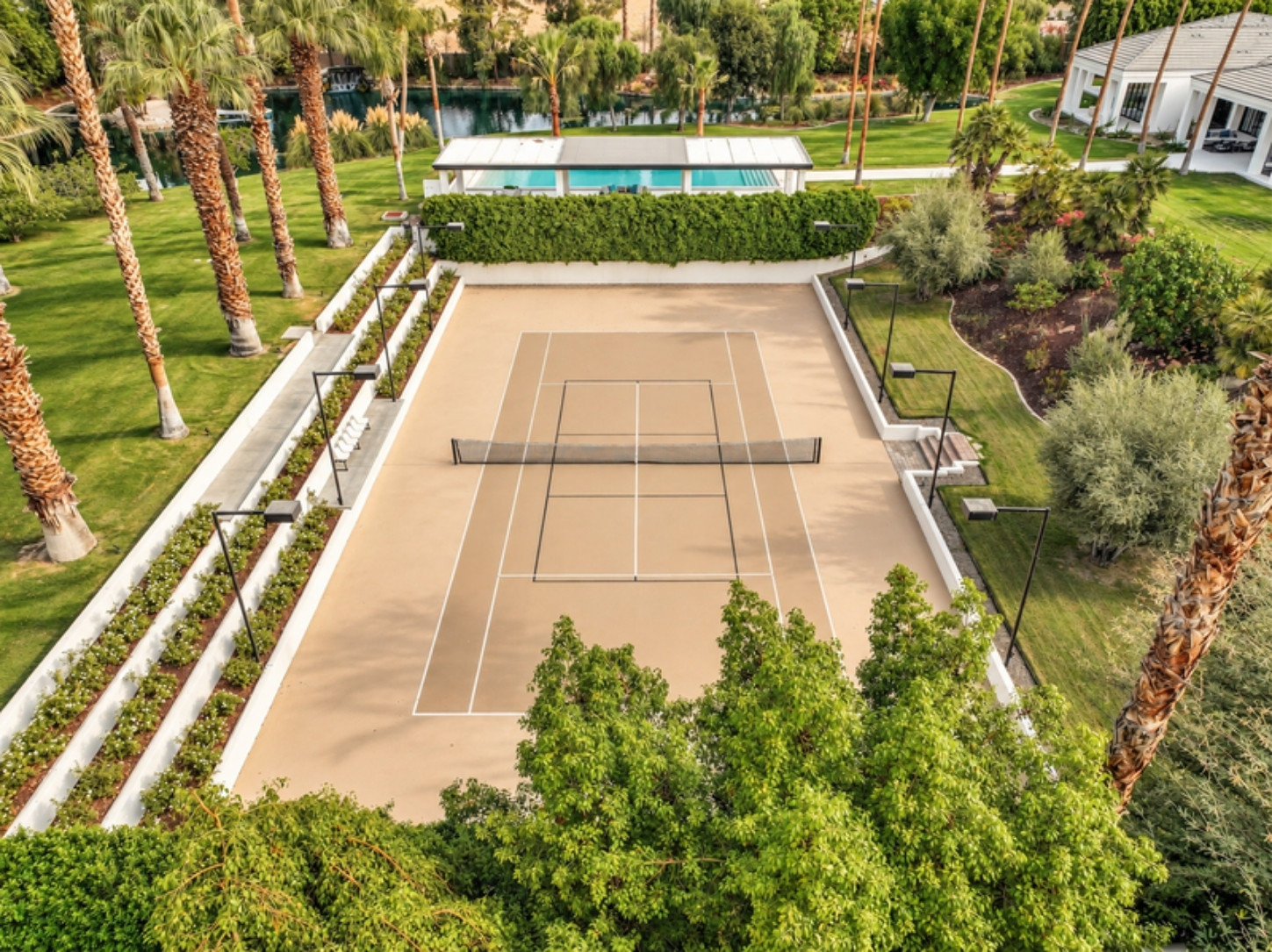 Aerial view of the sunken tennis court at Domus Atticus Estate in Rancho Mirage, terraced planting along both sides