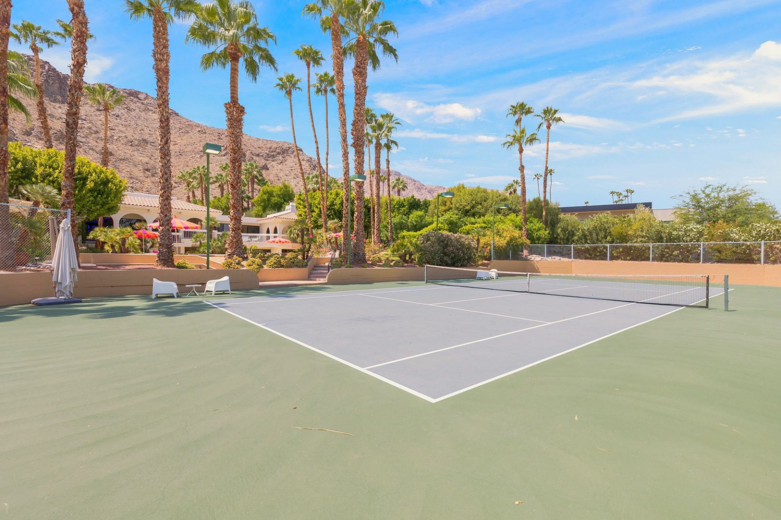 The sunken hard tennis court at Oroville Circle Estate, Rancho Mirage, with palms and the mountains behind