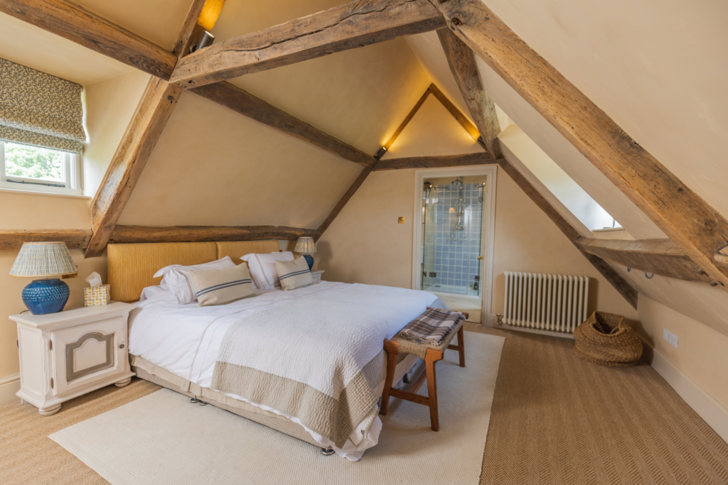 Attic bedroom with exposed oak beams and en suite bathroom